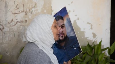 Frau hält ein Bild am Gesicht